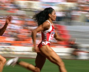 U.S. sprinter Florence Griffith Joyner of Los Angeles strides to a world record in a semifinal heat of the Olympic women's 200-meter dash in Seoul Thursday, Sept. 29, 1988.  Joyner's time of 21.56 seconds claimed the record and moved her into the finals in the event.(AP Photo/Lennox McLendon)